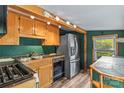A cozy kitchen with dark green walls, wooden cabinets, stainless steel appliances, and a window view at 2106 4Th Ne St, Hickory, NC 28601