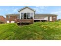 A brick house shows a sunroom, a generator, a small brick retaining wall, and a tiered deck in the backyard at 2459 Glenridge Dr, Gastonia, NC 28054