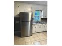 Kitchen featuring stainless steel refrigerator and sink with white cabinets and tile flooring at 2831 Denview Ln, Charlotte, NC 28208