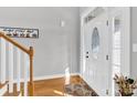 Inviting foyer featuring a decorative front door, hardwood floors, and staircase at 3068 Green Acres Ln, Claremont, NC 28610