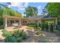 Expansive backyard with a covered patio, landscaped gardens, and an outdoor dining area, perfect for entertaining at 311 Mcalway Rd, Charlotte, NC 28211
