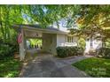 Attached carport offering convenient covered parking and access to the home, complete with manicured landscaping at 311 Mcalway Rd, Charlotte, NC 28211