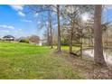 Spacious backyard with mature trees, a pond, and a swing, perfect for enjoying the outdoors at 32 Heritage Ln, Shelby, NC 28150