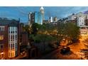 Scenic evening view of the Charlotte skyline from a residential area, highlighting city lights and greenery at 405 W 7Th St # 408, Charlotte, NC 28202