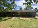 Relaxing backyard featuring a patio, lush lawn, mature trees, and a well-maintained exterior, perfect for outdoor living at 4230 Old Brittain Rd, Hickory, NC 28602