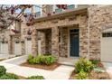 Inviting townhome entrance featuring stone columns, a blue front door and manicured landscaping at 5684 Garrow Glen Rd # 96, Charlotte, NC 28278