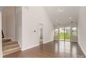 Bright living room featuring hardwood floors, neutral walls and sliding door to a green lawn at 5684 Garrow Glen Rd # 96, Charlotte, NC 28278