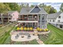 Gorgeous backyard features a stone patio with fire pit and a covered deck overlooking manicured landscaping at 602 Shoreline Rd # 144, New London, NC 28127