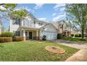 Traditional two-story home featuring a manicured lawn and an attached two-car garage with a covered entrance at 6618 Latherton Ln, Charlotte, NC 28278