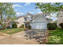 Traditional two-story home with a two-car garage, green lawn, and manicured bushes on a sunny day at 6618 Latherton Ln, Charlotte, NC 28278