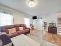 Bright living room featuring hardwood floors, a comfortable leather sofa, and ample natural light at 6820 Elm Forest Dr, Charlotte, NC 28212
