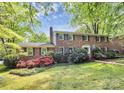 Charming brick two-story home with colorful flowers and a lush green lawn at 7020 Leesburg Rd, Charlotte, NC 28215