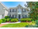 Beautiful two-story gray brick home featuring manicured landscaping, a front lawn, and a welcoming entrance at 709 Circle Trace Rd, Monroe, NC 28110