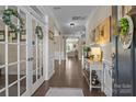 Inviting foyer with hardwood floors, paneled wainscoting, decorative accents and French doors at 7693 Lazy Hollow Ln, Denver, NC 28037