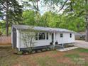Charming single-story home featuring white siding, a metal roof, and a well-manicured front lawn at 8475 Nc 49 N Hwy, Mount Pleasant, NC 28124