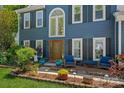 Inviting front porch with decor, colorful flowers, and blue chairs at 8651 Walsham Dr, Charlotte, NC 28277