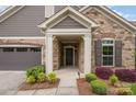 Close-up of the stone-faced front entrance showcasing the covered porch and manicured landscaping at 1008 Avalon Pl, Matthews, NC 28104