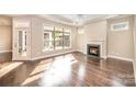 Bright and airy living room featuring hardwood floors, a fireplace, and a large window with natural light at 1008 Avalon Pl, Matthews, NC 28104