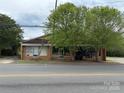 Commercial building available for sale with two shade trees and an inviting facade at 103 E Main St, Dallas, NC 28034