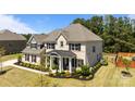 Beautiful two-story brick home with a well-maintained lawn, professional landscaping, and a welcoming porch at 1052 Harlow'S Crossing Dr, Weddington, NC 28104