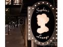 Sophia's Lounge sign along a sidewalk showcasing a vintage aesthetic in black, white and grey at 127 N Tryon St # 301, Charlotte, NC 28202