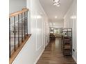 Long hallway with hardwood floors, elegant trim, and access to the living room and staircase at 1313 Loggerhead Dr, Lancaster, SC 29720