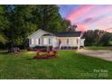 Charming single-story home featuring red shutters, a covered porch, and a lush green lawn at 1325 Red Oaks Dr, Rock Hill, SC 29730