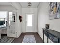 Bright entryway with hardwood floors, an elegant light fixture, and a view into the office space at 15127 Oleander Dr, Charlotte, NC 28278