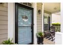 Charming front porch featuring a modern light blue door, a decorative wreath, and cozy outdoor seating at 2012 Galty Ln, Charlotte, NC 28270