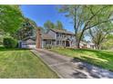 Traditional two-story home with an attached garage and a long driveway, surrounded by mature trees at 218 Kimrod Ln, Charlotte, NC 28270