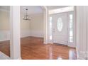Welcoming foyer featuring hardwood floors, decorative molding and a front door with glass panel at 2415 Tory Oak Pl, Matthews, NC 28105