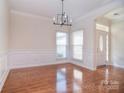 Bright foyer showcases hardwood floors and modern chandelier at 2415 Tory Oak Pl, Matthews, NC 28105
