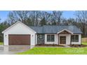 Stunning new home with white siding, stone accents, and a covered front porch at 28647 Nc Hwy 73 Hwy, Albemarle, NC 28001