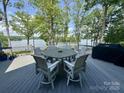 Outdoor deck features dining table and chairs with wooded waterfront views at 302 Patterson'S Bridge None, New London, NC 28127