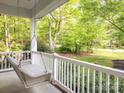 Relax on the inviting porch swing while enjoying the views of the beautifully landscaped yard at 3033 Beech Ct, Indian Trail, NC 28079