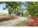 A single-story stucco home with stone accents, large driveway, and lush landscaping and a detached garage at 3764 Glenn Oaks Dr, Maiden, NC 28650