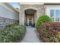 Inviting stone-arched entryway with a decorative front door, flanked by lush landscaping at 4012 Brandywine Ter, Lancaster, SC 29720