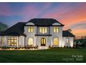 Stunning two-story home with a manicured lawn and elegant architectural details, illuminated at twilight at 405 Sugar Maple Ln # 41, Weddington, NC 28104