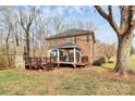 Backyard with deck featuring a gazebo and a stone fireplace, surrounded by mature trees at 503 Bridgestone Ct, Gastonia, NC 28056