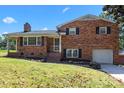 Charming brick two-story home with well-manicured lawn and attached garage at 5301 Baker Dr, Charlotte, NC 28210