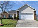 Traditional home with a two-car garage, brick accents, and manicured lawn at 5927 Patricia Ryan Dr, Charlotte, NC 28216