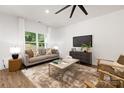 Bright living room with a comfortable couch, large window, and a modern ceiling fan at 6524 Robert St, Huntersville, NC 28078
