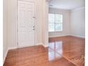 Bright entryway features hardwood floors, white door and trim, and a view into the living room at 7206 Forrest Rader Dr, Mint Hill, NC 28227