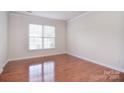 Bright living room showcasing hardwood floors, large window letting in an abundance of natural light at 7206 Forrest Rader Dr, Mint Hill, NC 28227