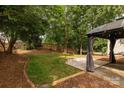 Landscaped backyard featuring a gazebo with outdoor seating on a well-maintained lawn at 8607 Cedardale Ridge Ct, Charlotte, NC 28269