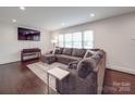 Comfortable living room with dark hardwood floors, large sofa and natural light at 901 Burnley Rd, Charlotte, NC 28210