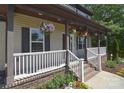 Inviting front porch adorned with hanging flower baskets, providing a charming and welcoming entrance at 1021 Vickie Ln, Matthews, NC 28104
