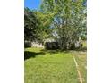 Tan single-story home featuring a lush lawn and mature trees at 104 Poplar St, Clover, SC 29710