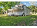 Angle view of a well-maintained home with a welcoming porch, green lawn, and mature trees at 126 Hemphill Ave, Chester, SC 29706