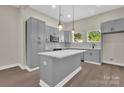 Bright kitchen with gray cabinets, center island, stylish pendant lights, and stainless steel appliances at 126 Hemphill Ave, Chester, SC 29706